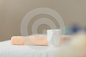 Focus of white cup and beige towel in spa