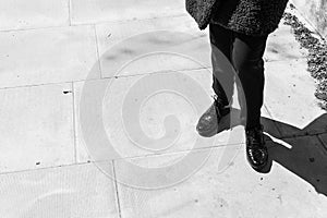 Focus on woman legs wearing London style black leather brogues photo