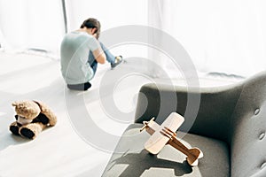 Focus of wooden plane on armchair and kid with dyslexia on background