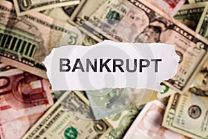 Focus on the word BANKRUPT on piece of torn white paper with blu