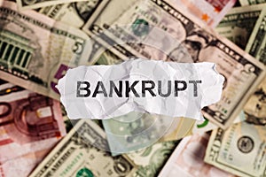 Focus on the word BANKRUPT on piece of torn white paper with blu