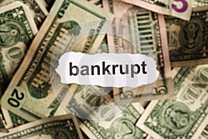 Focus on the word BANKRUPT on piece of torn white paper with blu