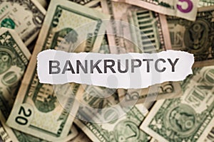 Focus on the word BANKRUPTCY on piece of torn white paper with b