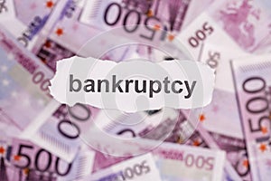 Focus on the word BANKRUPTCY on piece of torn white paper with b