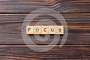 focus word written on wood block. focus text on table, concept