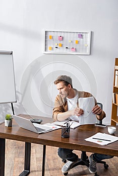 Focus of young businessman holding papers