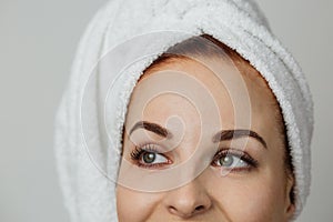 Focuse un eyes. Close up portrait of pleasant young woman in towel.