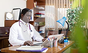 Focused african american doctor works at a computer in an office