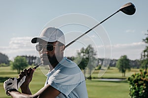 Focused african american man playing golf at golf course