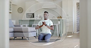 Focused african american man practising yoga meditation in sunny living room, slow motion