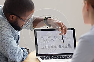 Focused african analyst showing annual financial report on laptop screen