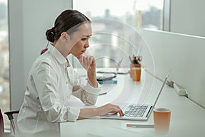 Focused asian business woman working laptop sitting in modern office