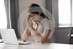 Focused asian businesswoman put hands in prayer at work