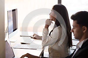 Focused Asian employee busy working at pc in coworking space