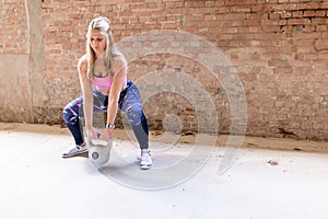 Focused Athlete Performing Kettlebell Squats in a Minimalistic Gym Setting