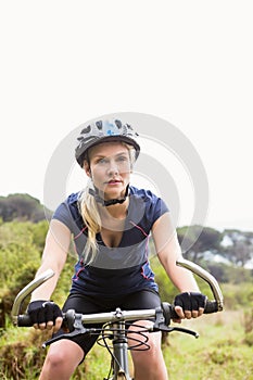 Focused athletic blonde mountain biking