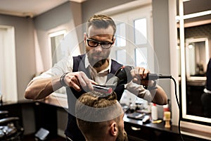 Focused barber drying customer hair
