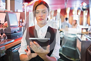 Focused barmaid using touchscreen till
