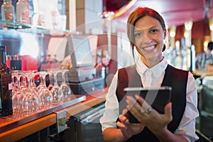 Focused barmaid using touchscreen till