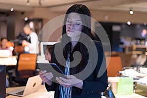 Focused beautiful  young businesswoman using a digital tablet while has a live meeting via social network together with her