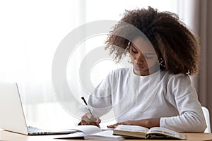 Focused black girl study at home doing homework