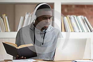 Focused black male student studying at laptop at home