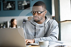 Focused black student studying online in coffeeshop photo