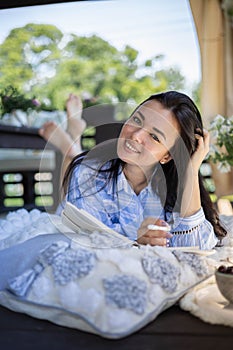 Focused brunette woman thinking imagination with notepad at nature summer outdoor village terrace