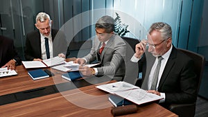 Focused business people in formal wear reading some documents while having a meeting in the office