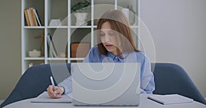 Focused business woman entrepreneur typing on laptop doing research. Young female professional using computer sitting at