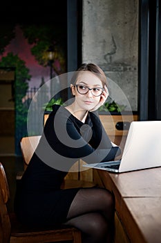 Focused business woman sit on cafe working on laptop, concentrated serious female working with computer and notebook in coffee sho
