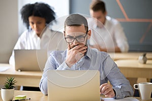 Focused businessman solving online problem working on laptop in