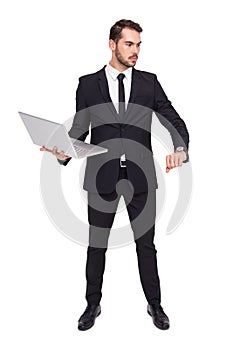 Focused businessman in suit holding laptop