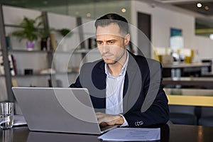 Focused businessman in suit working on his laptop