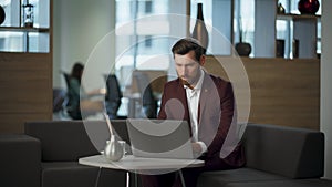 Focused businessman working laptop sitting office. Pensive worker typing device