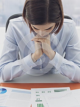 Focused businesswoman checking financial reports and thinking