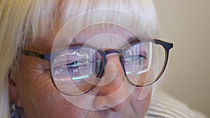 Focused businesswoman eye looking monitor, surfing Internet. Female with glasses eyes looking at the monitor in dark