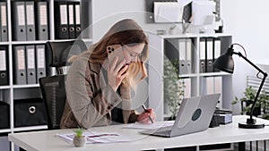 Focused Businesswoman Talking Phone And Working In Office