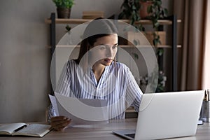 Focused busy young office employee working at laptop