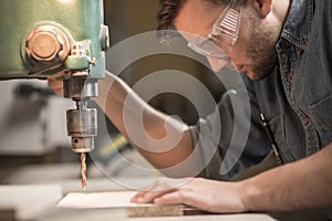 Focused carpenter working with machine