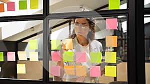 Focused Caucasian woman develop idea on sticky notes