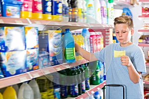 Focused cheerful boy looking at shopping list