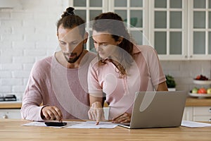 Focused concerned family couple managing budget.