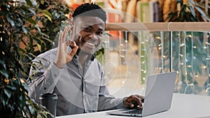 Focused confident businessman working remotely typing on laptop serious young male manager looking at camera smiling