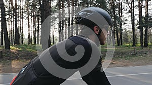 Focused confident cyclist riding bicycle in the park. Side follow shot. Cycling concept. Slow motion
