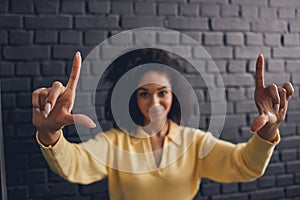 Focused curly-headed lady showing a hand gesture