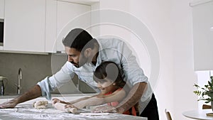 Focused dad teaching daughter to bake