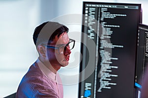 Focused developer and programmer works at modern office workstation, coding and debugging software on dual monitors. Technology-