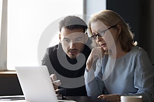 Focused employees, business man and woman talking at laptop