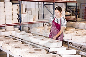 Female ceramicist filling casting molds with slip in pottery workshop photo